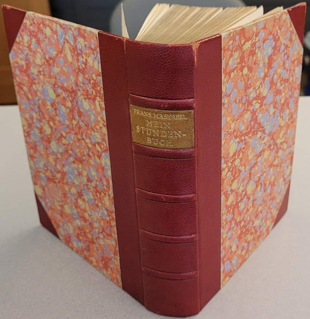 Masereel's 1920 wordless novel, Mein Stundenbuch, in red 3/4 leather with reddish marbled boards.