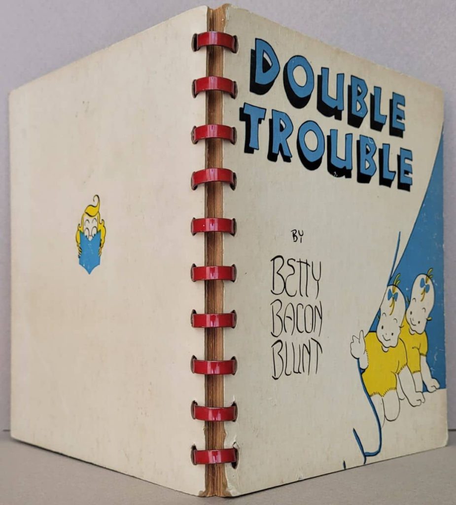 Metal comb spine with front and back covers of Betty
Bacon Blunt's wordless novel, Double Trouble.