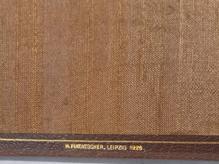 Name of the bookbinder, H. Fikentscher of Leipzig, and the 1920 date of binding stamped in gold on the bottom margin of the rear paste-down.